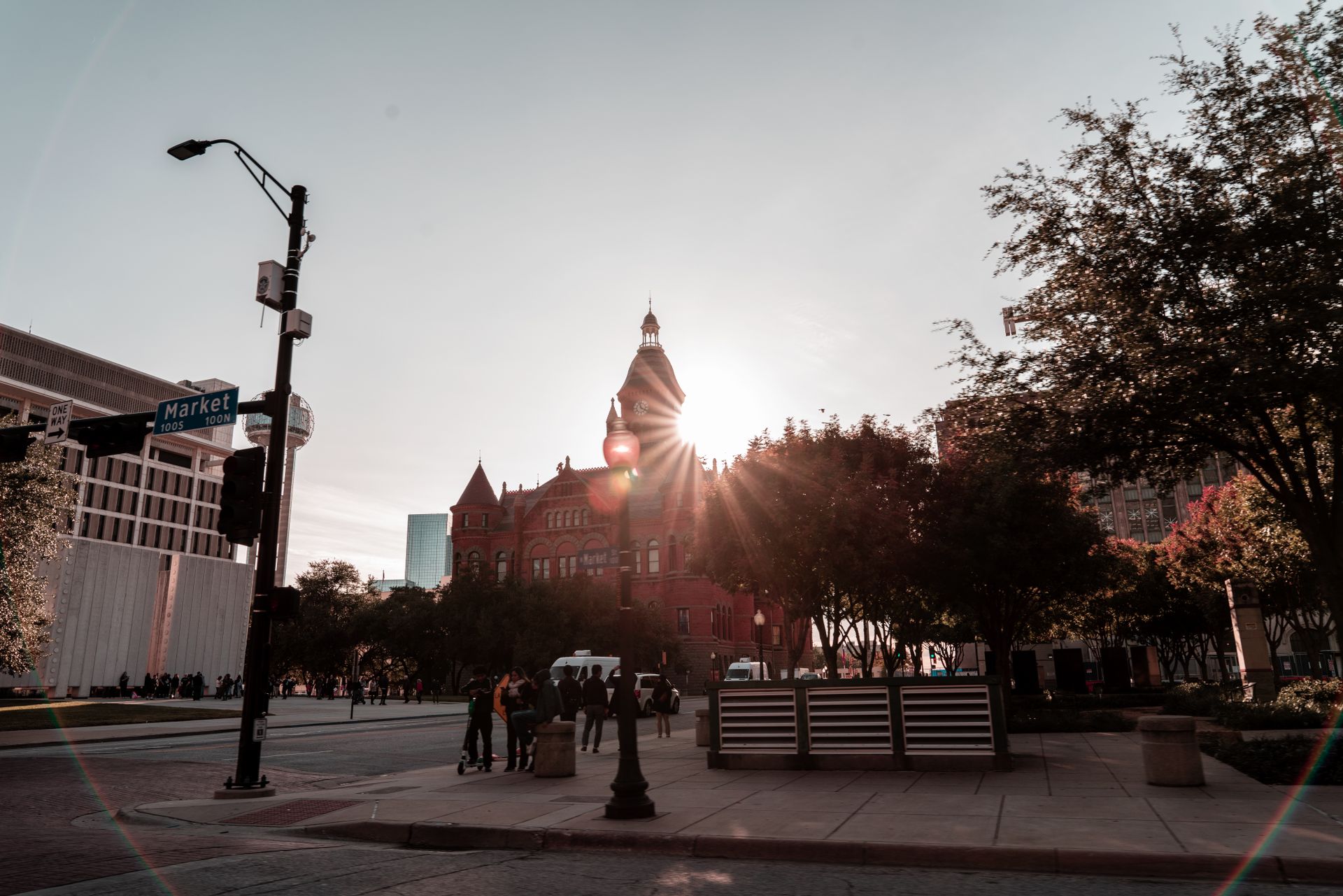 Dallas Victory Park at sunset with Market Street sign, historic red brick building, and modern skyline