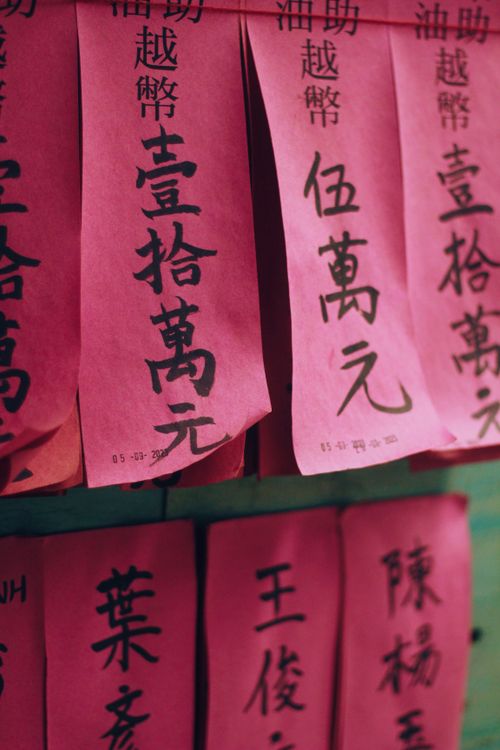 Free Vertical red papers featuring Chinese calligraphy, possibly representing wishes or blessings. Stock Photo