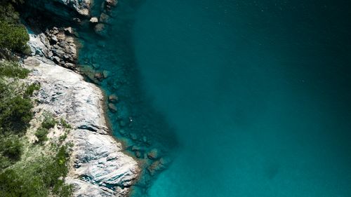 Free Stunning aerial view of rocky coastline meeting clear turquoise waters in Phuket, Thailand. Stock Photo