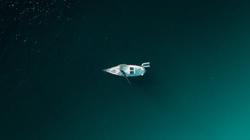 Белая лодка на зеленой воде