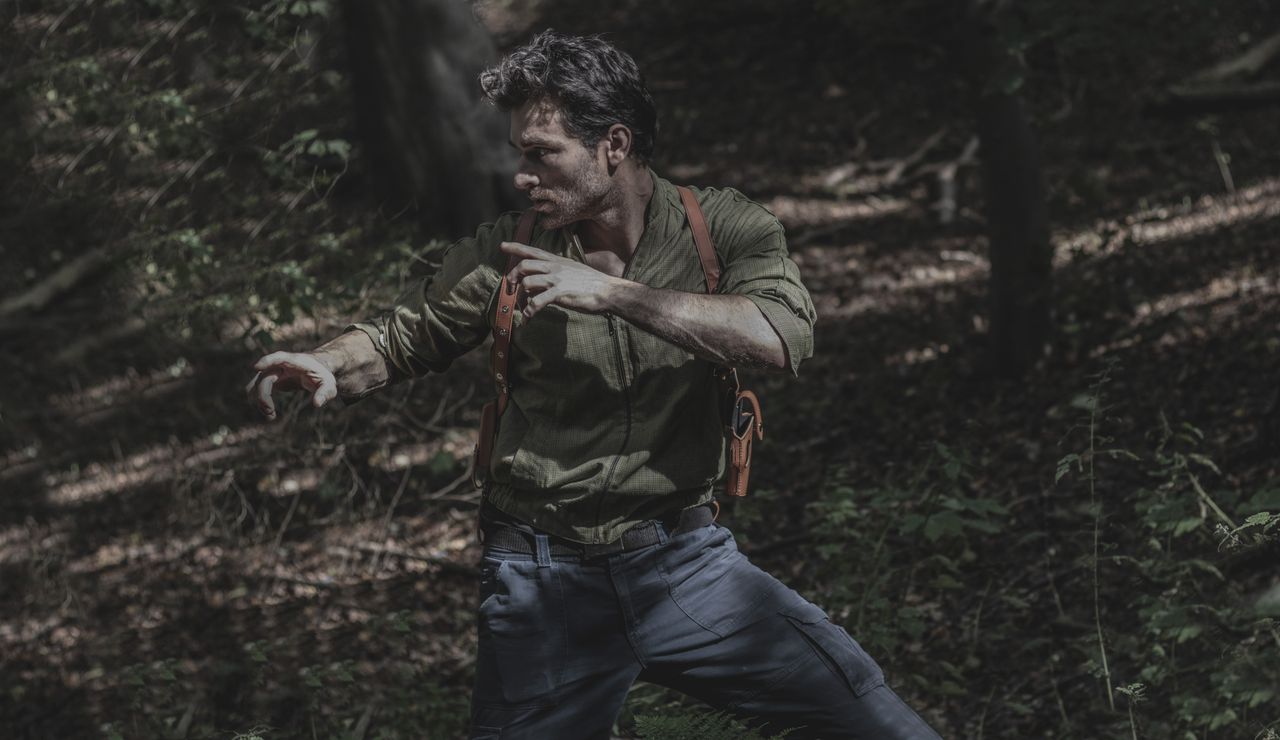 a man engages in martial arts practice amidst a dense forest environme