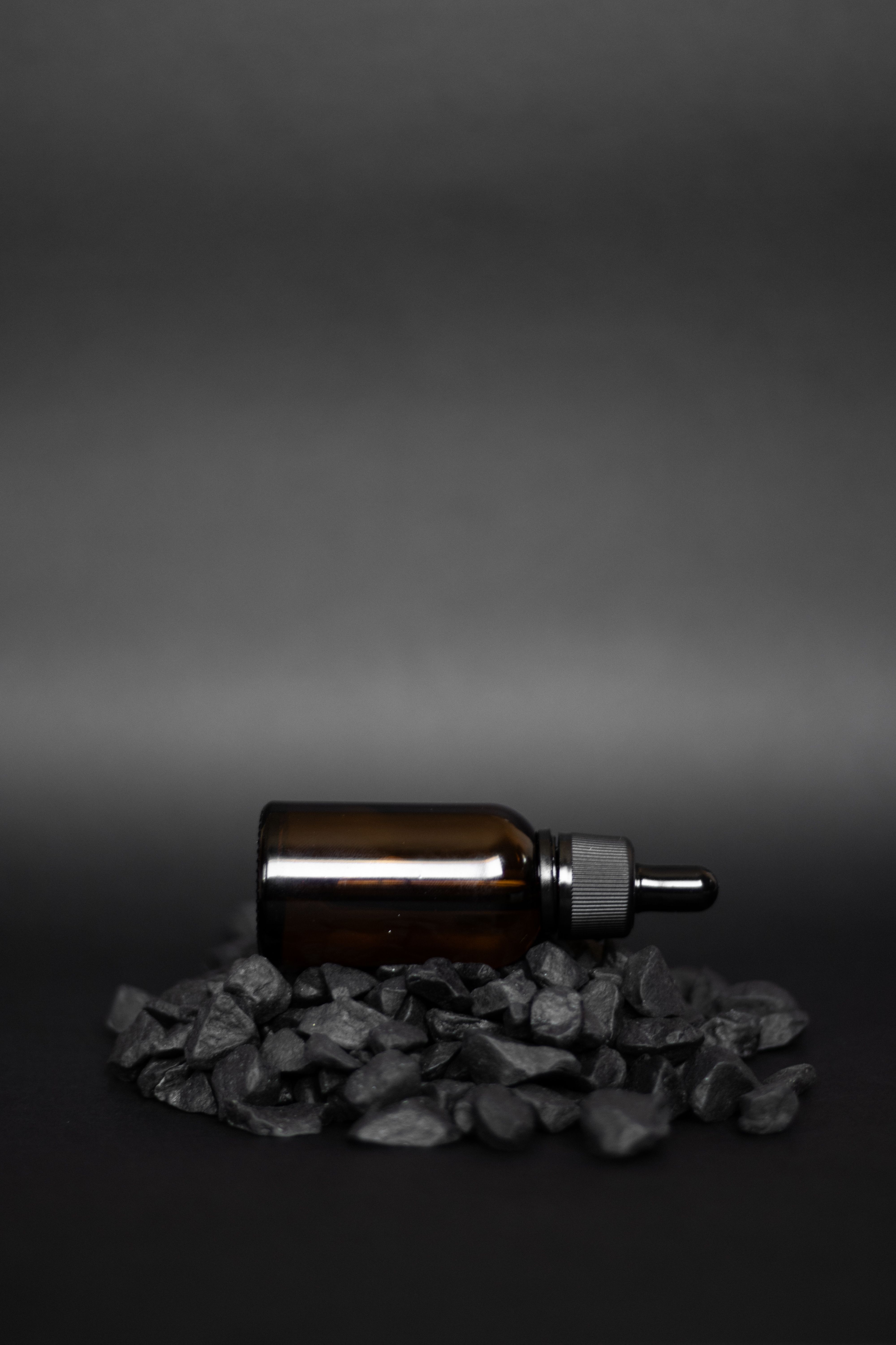 Botella de aceite esencial sobre fondo oscuro