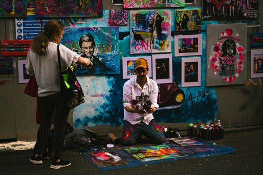 Colorful street art scene with artist and viewer in Galway, Ireland.