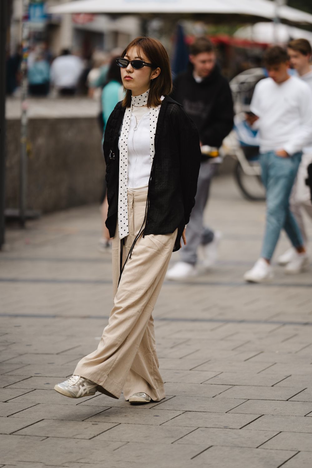 Helle weite Hose mit hellem Oberteil und offen getragener schwarzer Jacke