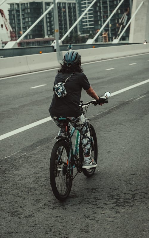 Woman on Bike on Street on Bridge