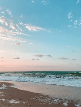 Peaceful beach at sunrise with gentle waves and warm hues creating a serene atmosphere.