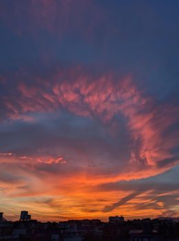 Stunning evening cloudscape with vibrant colors over an urban skyline.