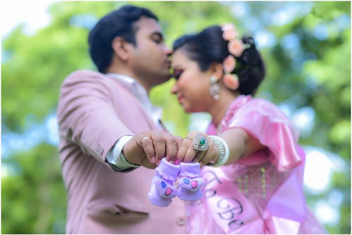 A Couple Showing Little Baby Shoes 