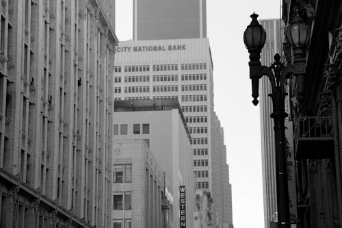 Grayscale Photo of Lamp Post and Buildings