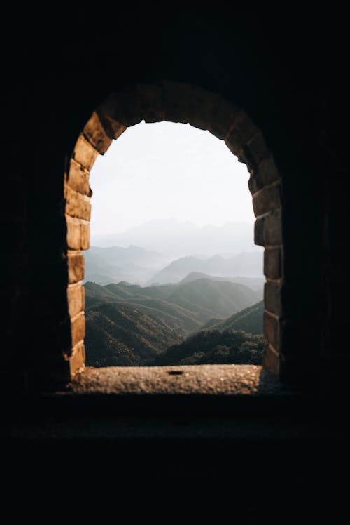 Arched Window Overlooking Mountains in Morning Fog