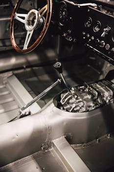 复古汽车内饰特写，木制方向盘和手动变速杆的设计凸显了复古风格