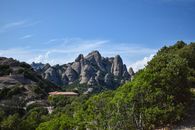 Stunning view of Montserrat mountains with lush greenery under clear blue skies in Spain.