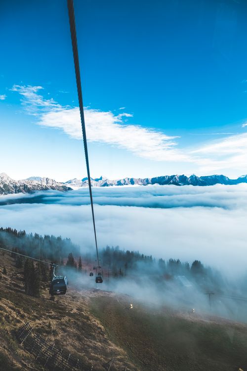 Free Serene cable car journey over misty mountains and clouds, offering breathtaking views. Stock Photo