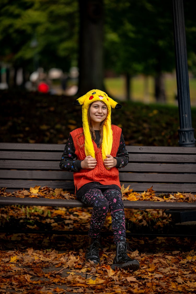 Smiling Woman In Pokemon Hat On Bench In Park