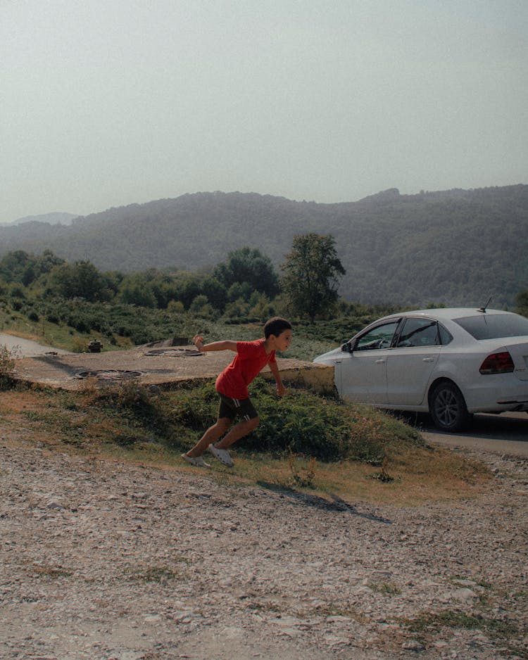 Boy Running Near Car