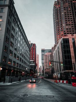 Urban cityscape showing tall buildings and street with cars in a bustling downtown area.