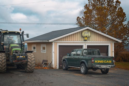 Tractor and Pickup Truck by the Garage on the Farm