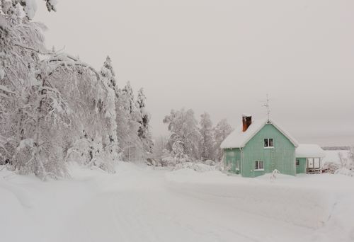 Free Serene snowy landscape with a green cabin in Aavasaksa, Finland. Stock Photo