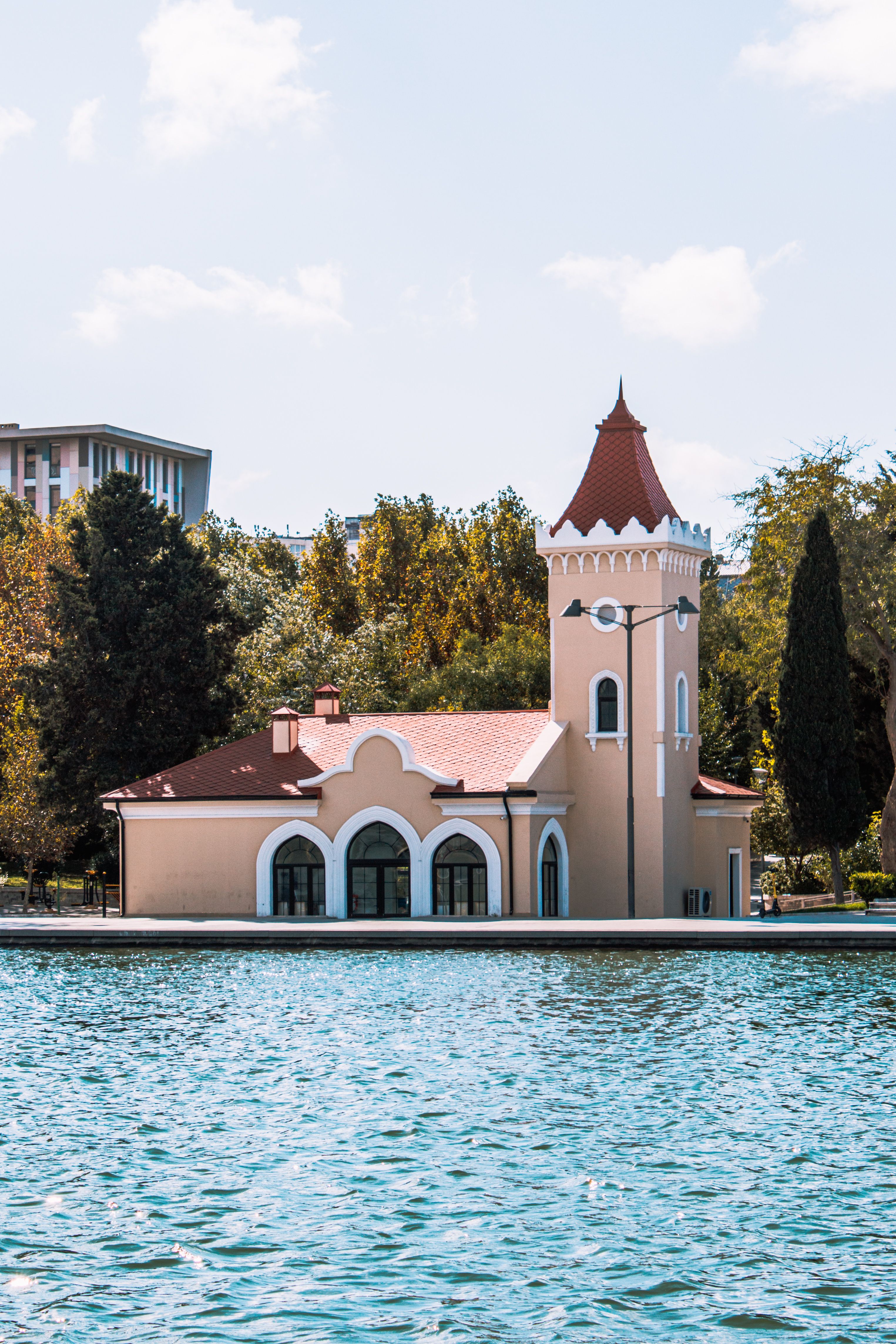 Picturesque building by an artificial lake in Baku, featuring unique architecture and lush surroundings.