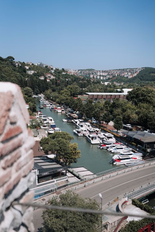 Free Aerial view of a vibrant marina with boats moored along a tree-lined river in summer. Stock Photo