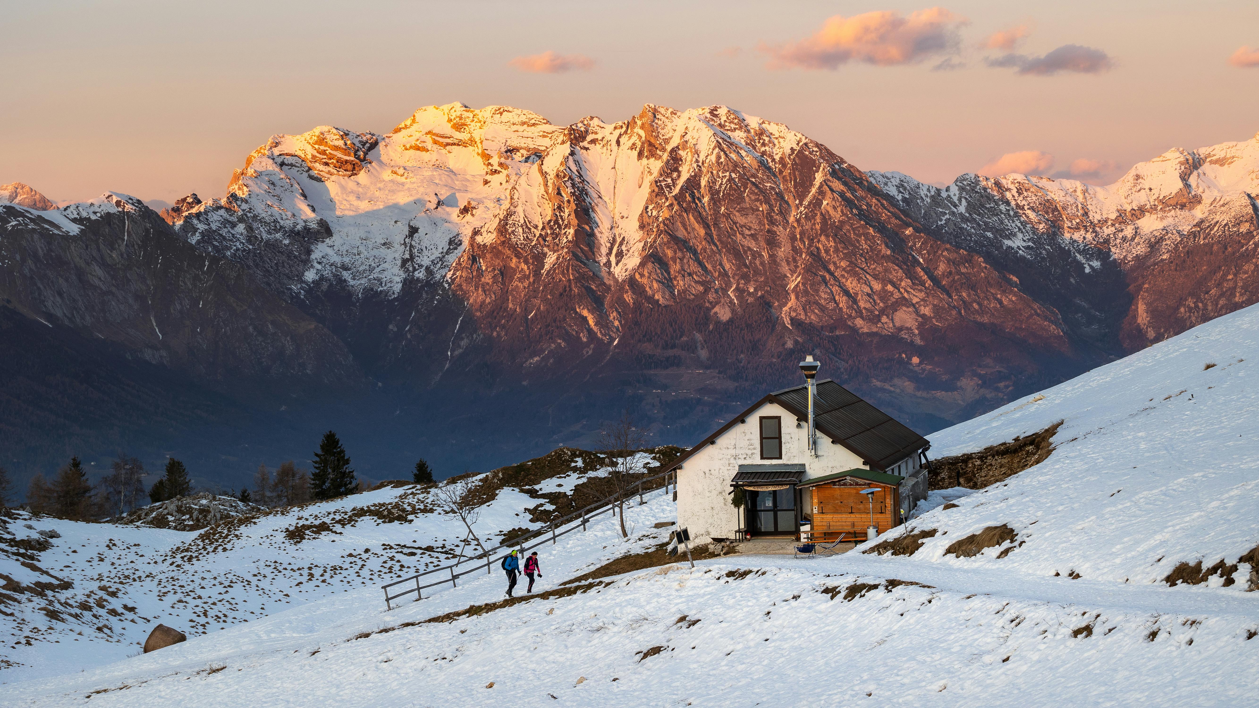 Prescription Goggle Inserts - Scenic winter landscape with an alpine cabin and sunset-lit mountains in the background.