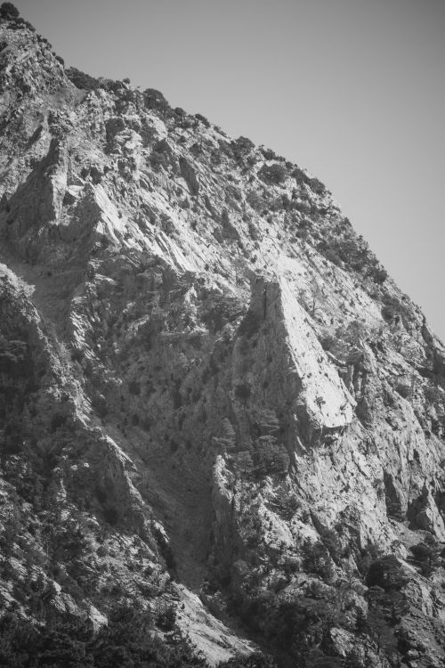 Free Striking black and white photo of a rugged rocky mountain, highlighting texture and depth. Stock Photo