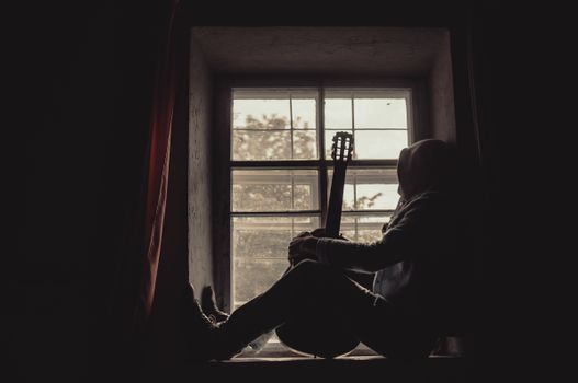 Person with Guitar Sitting on Windowsill