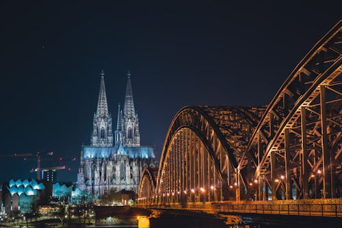 Illuminated Cologne Cathedral and Hohenzollern Bridge at Night
