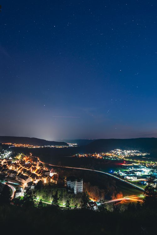 Free Stunning night view of Mühlheim an der Donau with starry sky and illuminated cityscape. Stock Photo