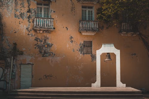 Bell in front of a Weathered Building