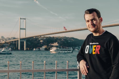 Man Posing in Front of a Suspension Bridge in Istanbul