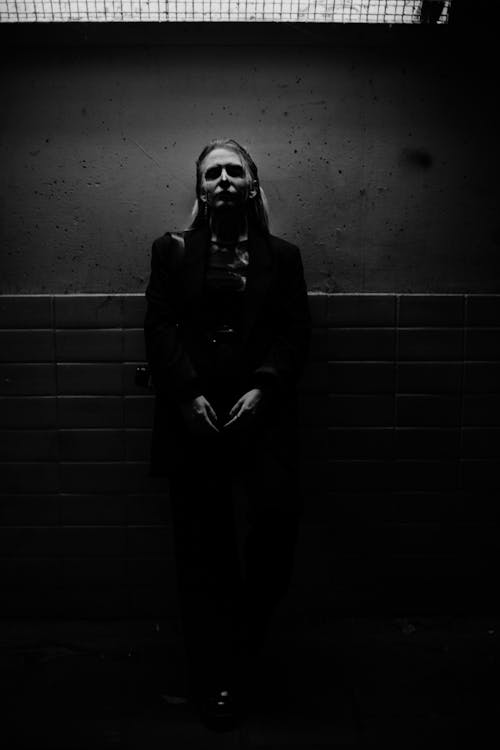 Spooky Woman Standing by Wall in Dark