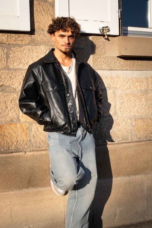 Male Model Wearing a Black Leather Jacket Leaning on a Wall