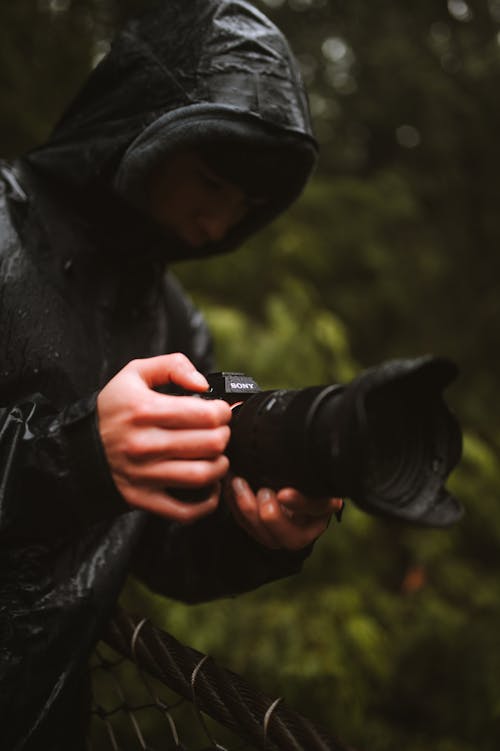 Man Holding a Camera in a Forest