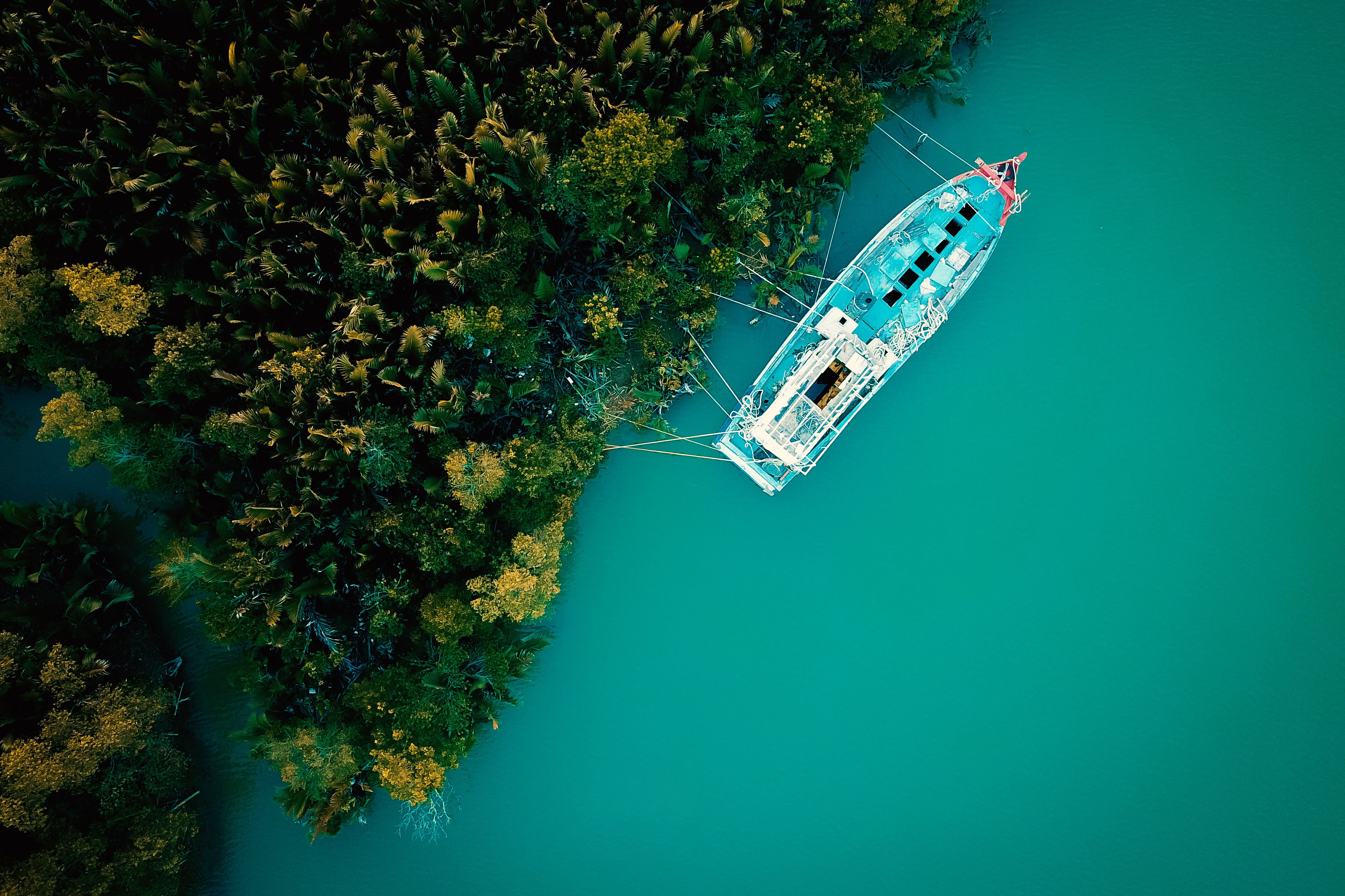 Aerial View of a Boat Moored in a Turquoise Lake · Free Stock Photo