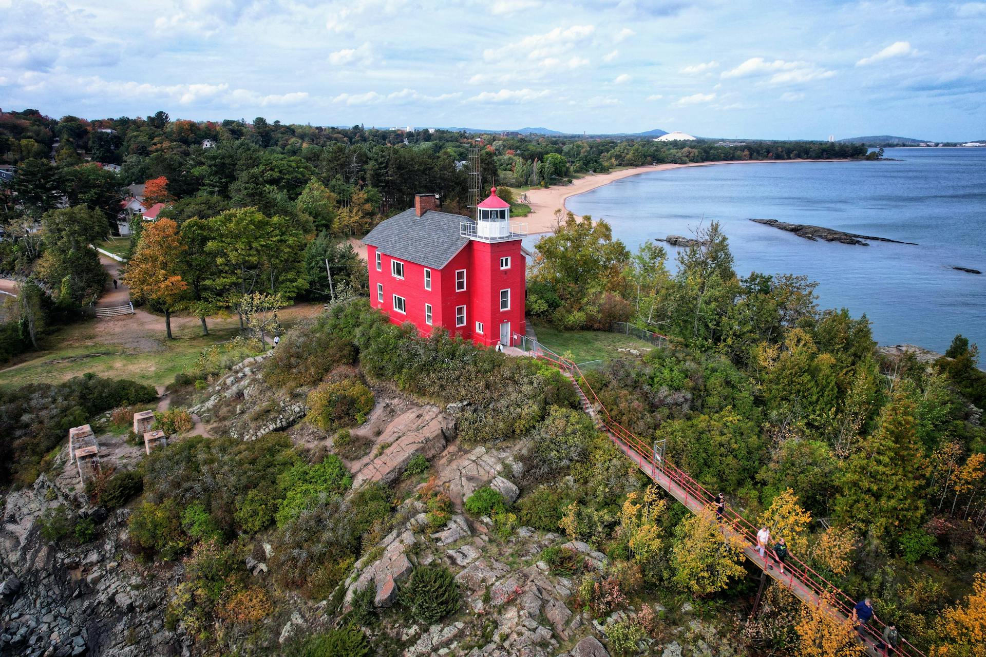 Discover the iconic Marquette Harbor Lighthouse against the scenic Lake Superior shore.