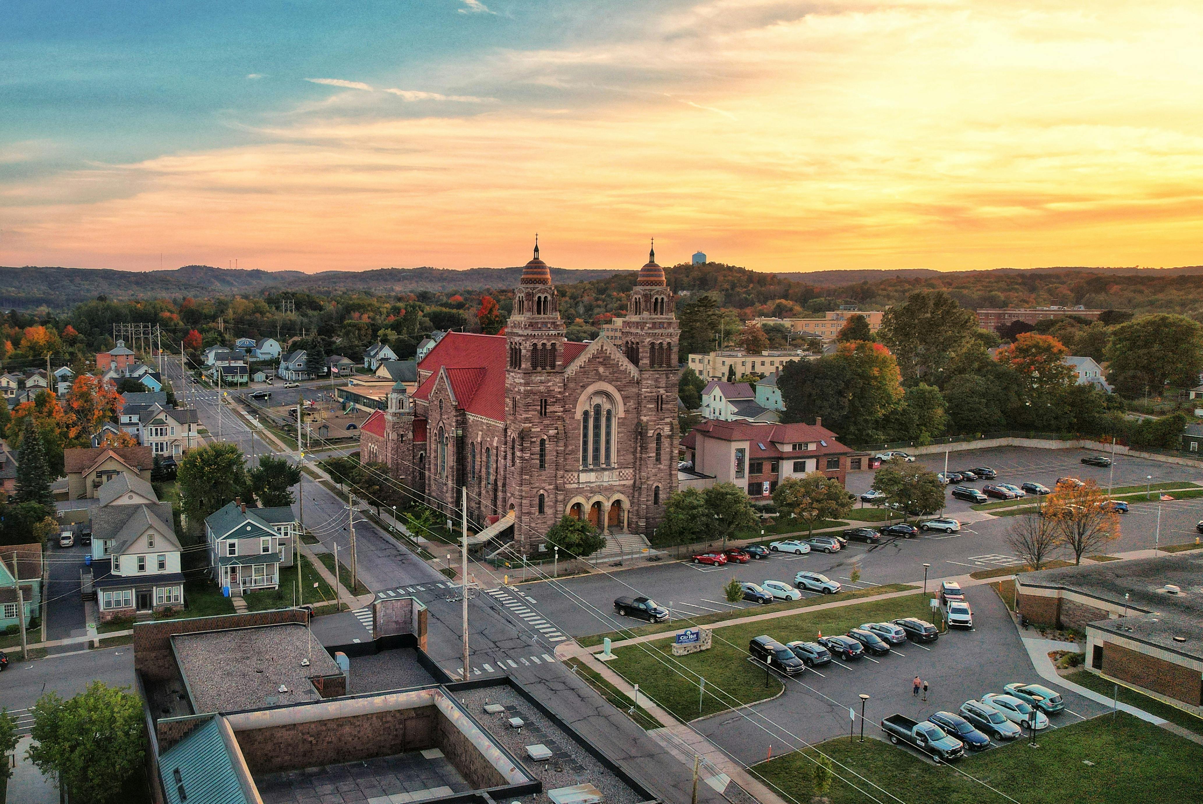 Beautiful aerial view of Saint Peter Cathedral in Marquette, MI during sunset, showcasing the architecture and surroundings.