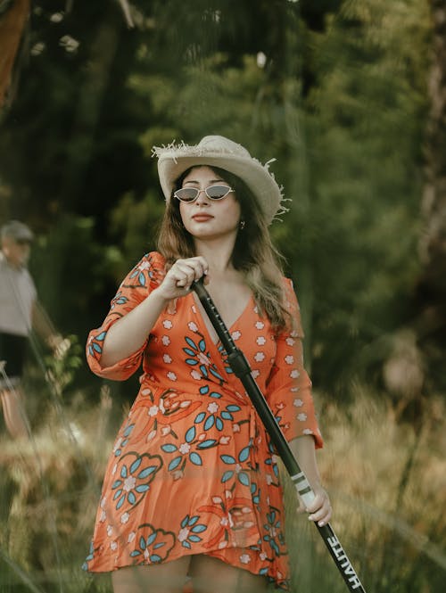 Woman in Hat and Sundress Holding Club