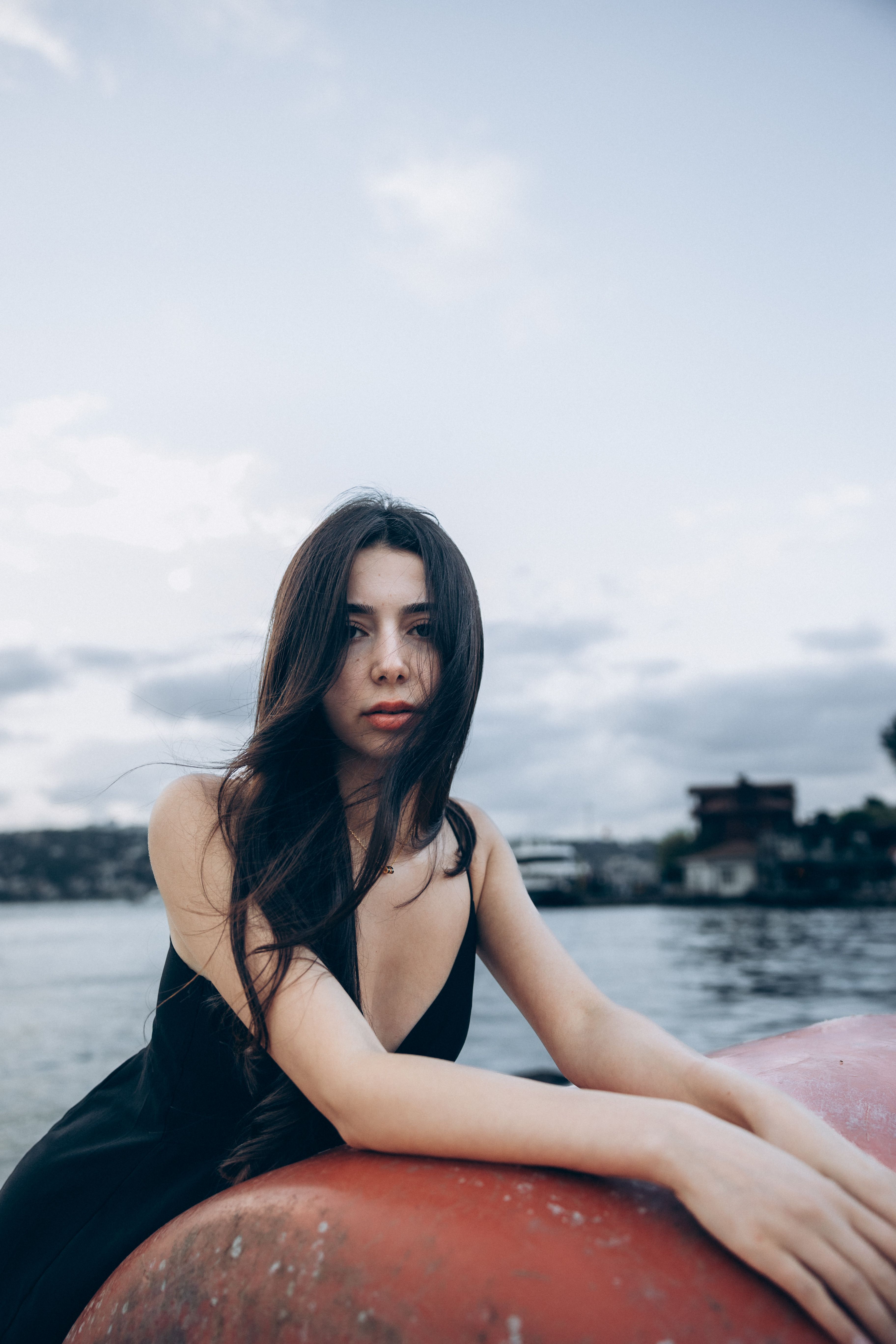 A woman in a black dress sitting on a boat · Free Stock Photo