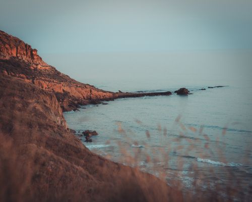 Free Tranquil coastal scene with rocky cliffs and calm sea at Sicilì, Italy. Stock Photo