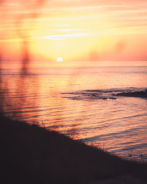 Free Capture the serene beauty of a peaceful sunrise over the ocean with gentle waves and vibrant colors. Stock Photo