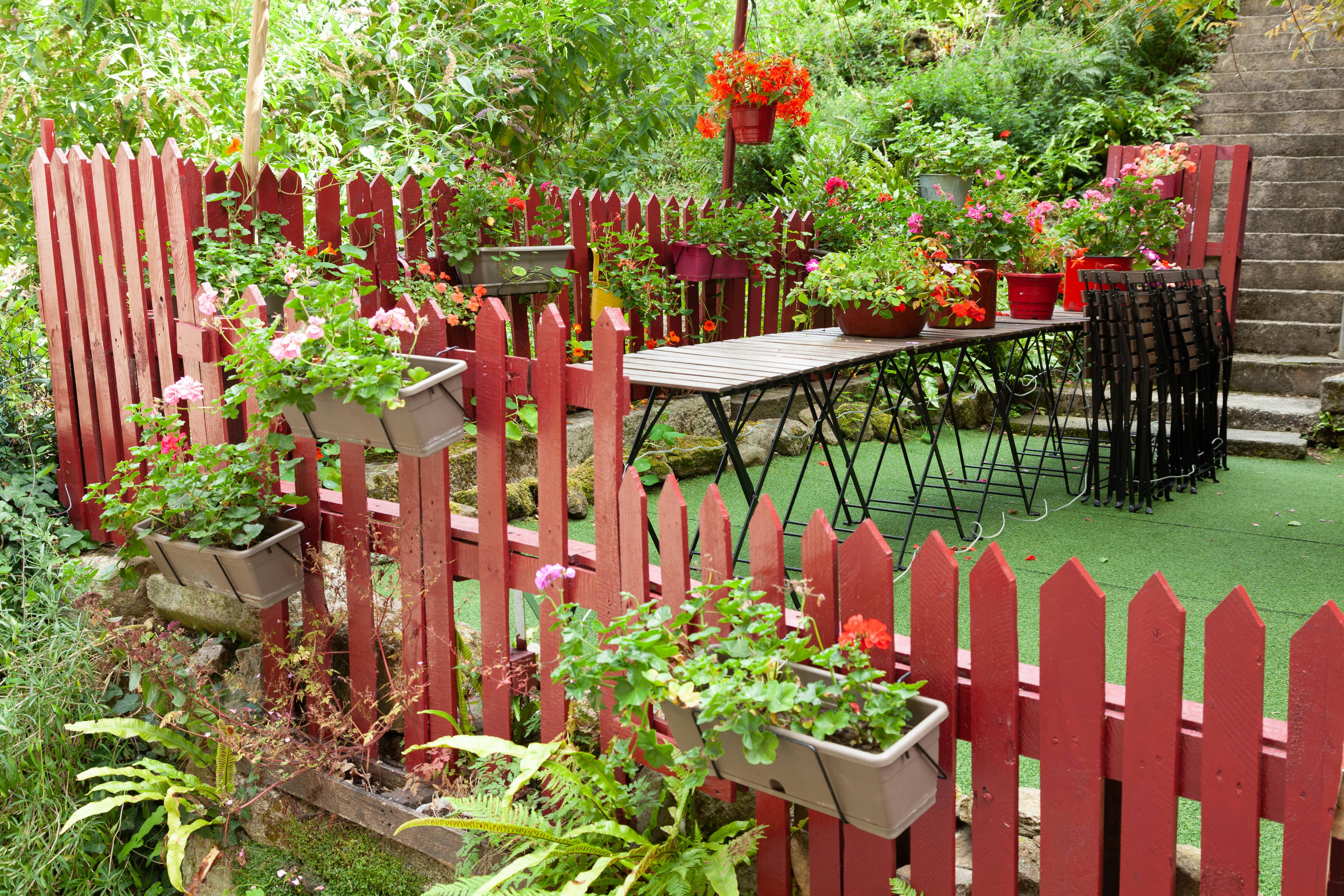 A vibrant garden terrace with red fence and flowers in Dinan, Brittany, France.