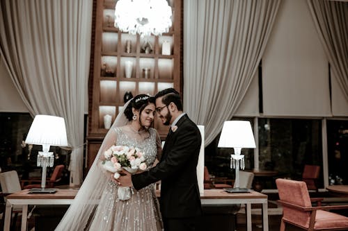 Newlyweds Standing Together with Flowers Bouquet