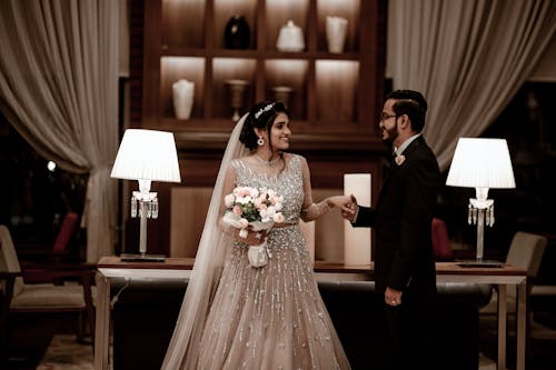 Smiling Newlyweds Standing and Holding Hands