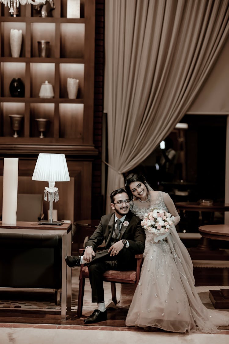 Smiling Newlyweds Standing And Sitting Together