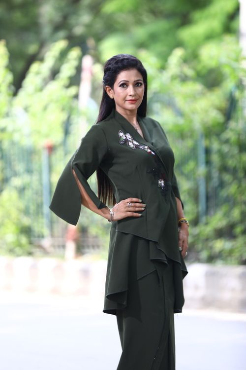 Free Fashion model posing elegantly outdoors in green attire, showcasing style. Stock Photo