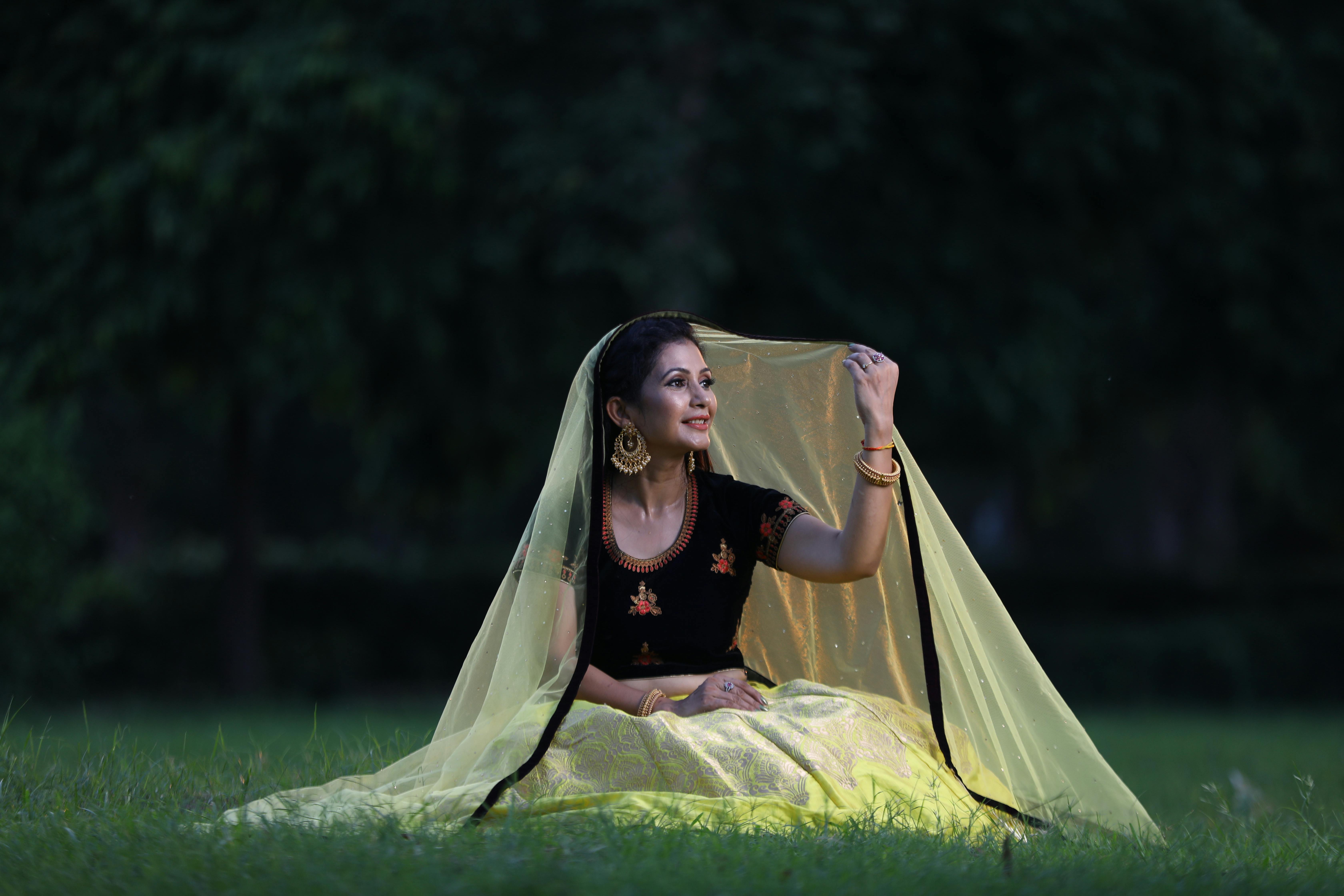 woman sitting in traditional clothing with yellow veil