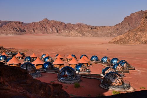 Free Futuristic geodesic domes in Wadi Rum desert surrounded by rocky mountains under clear sky. Stock Photo