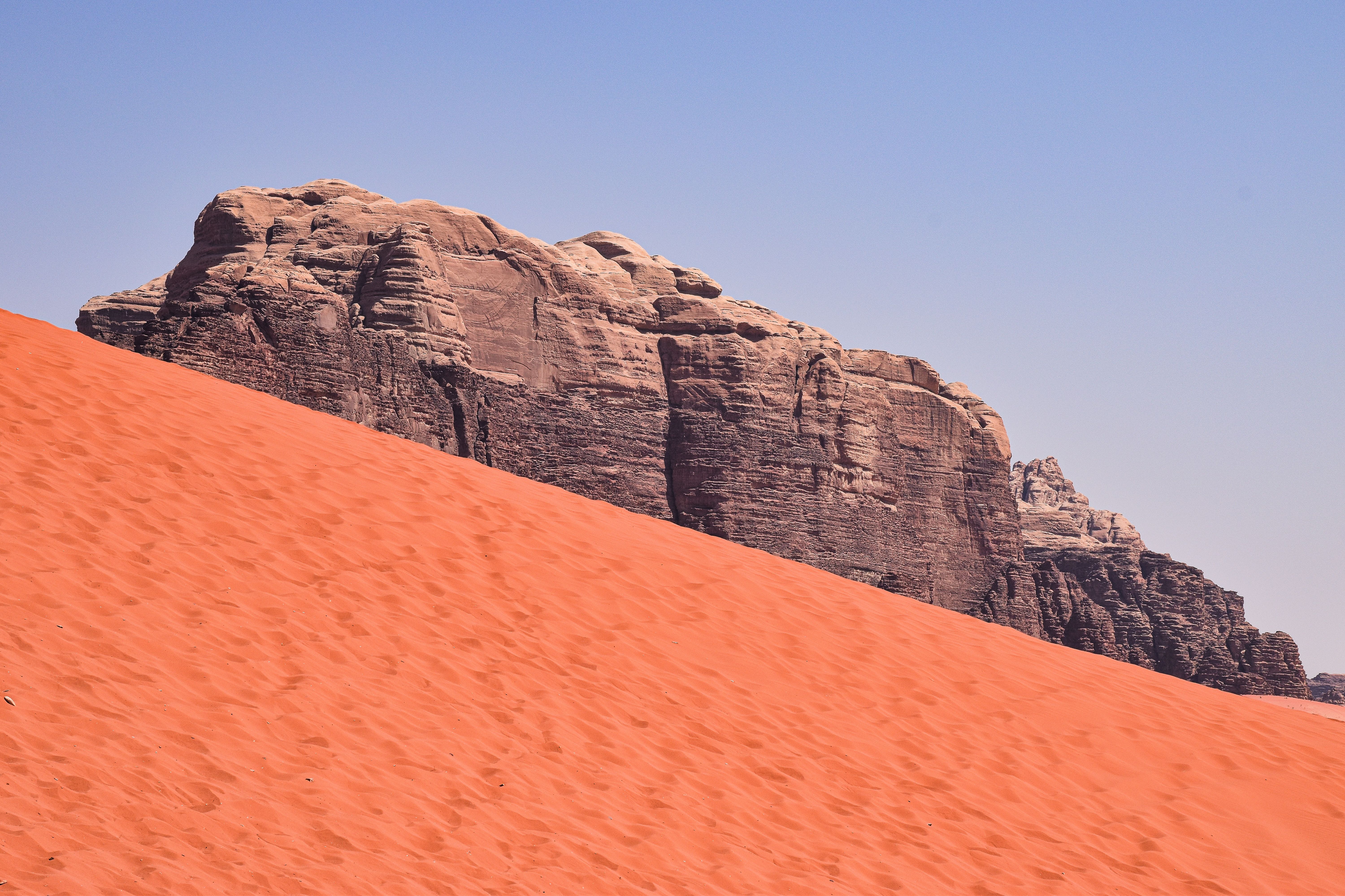 Red dunes banked against rugged massifs — terrain of the half-day Sunken Dunes tour