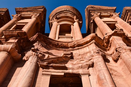 Free Low-angle view of the ancient Monastery in Petra, Jordan, highlighting its historic architecture under a clear blue sky. Stock Photo